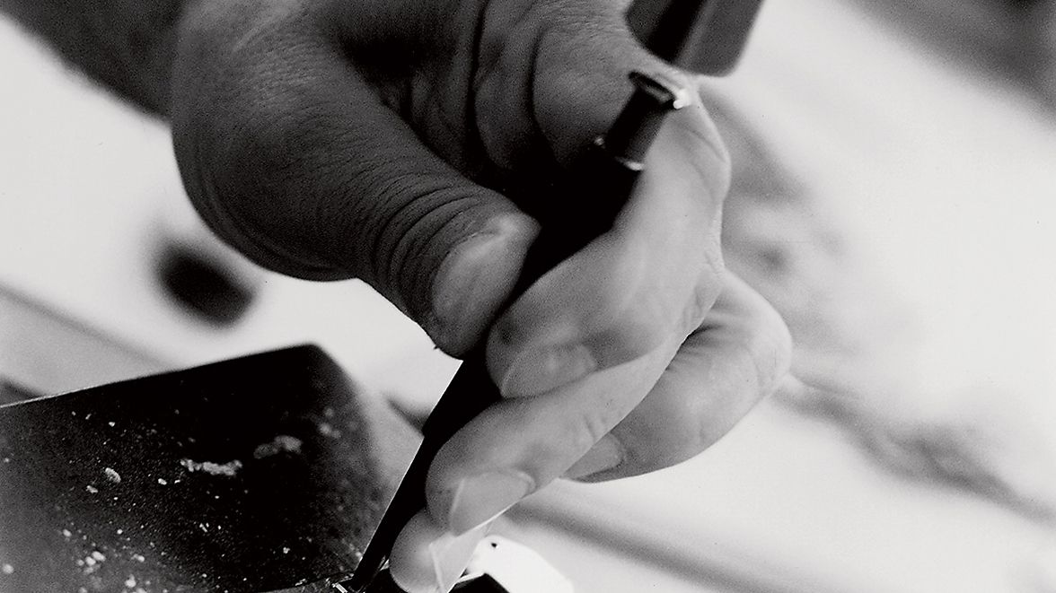 Close view of an Hermès artisan working leather by hand