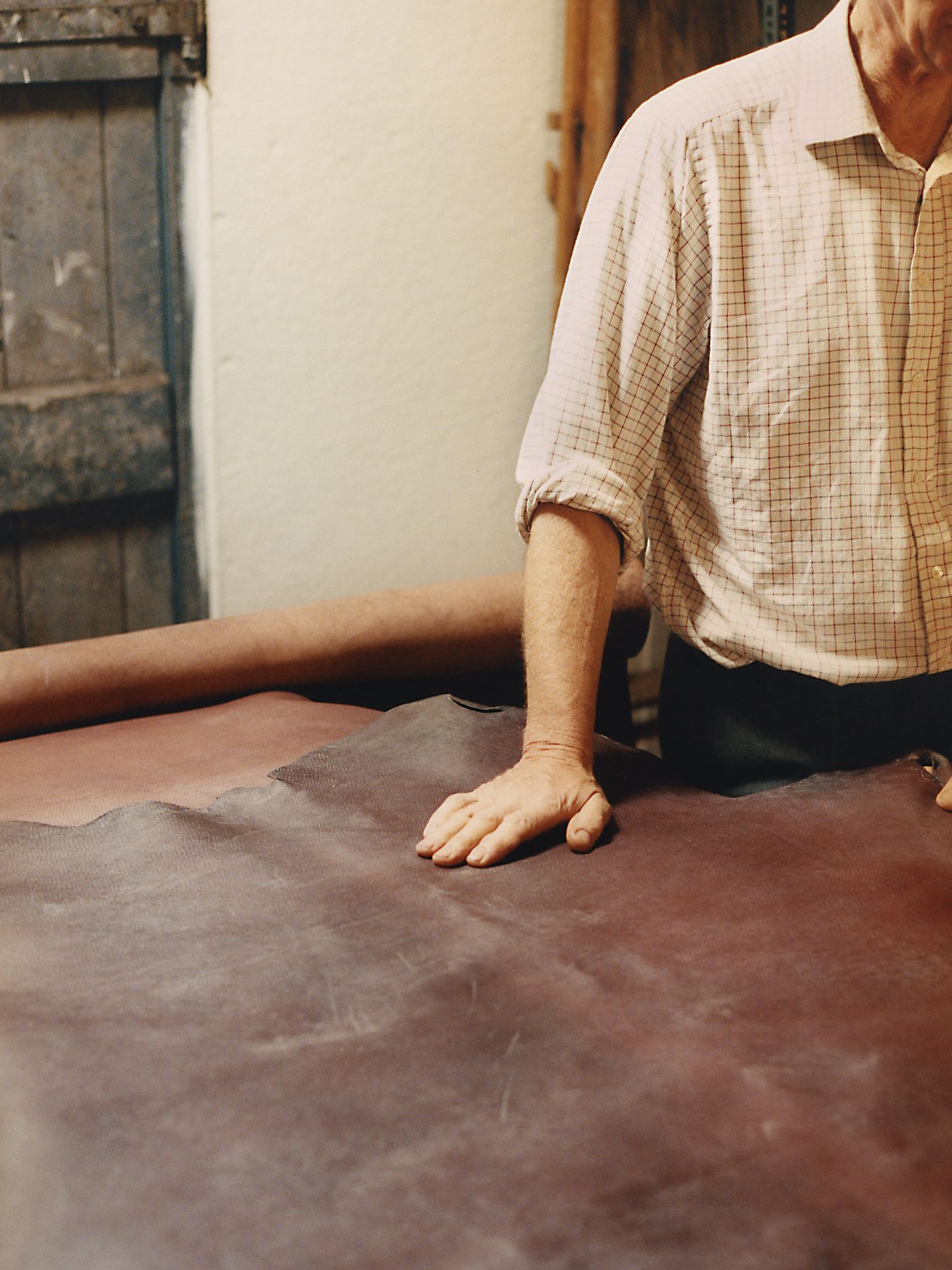 Hermès artisan assessing a large hide of leather