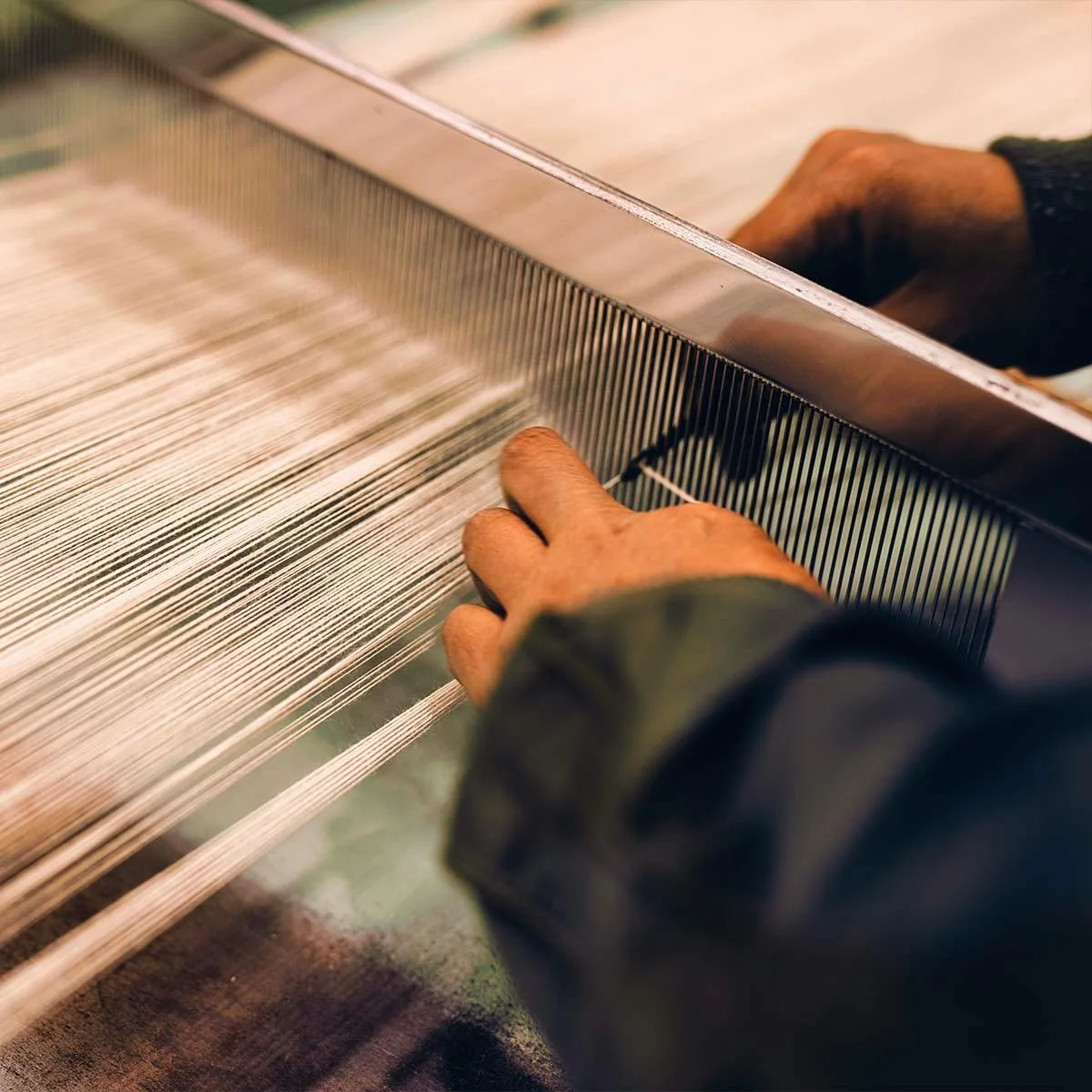 An artisan working at a loom within the LVMH Métiers d'Art network